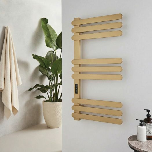 Brushed brass dry electric designer towel radiator with a digital display, mounted on a pale bathroom wall