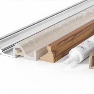 Chrome, marble effect and wood effect wall panel trims laid beside a tube of panel adhesive